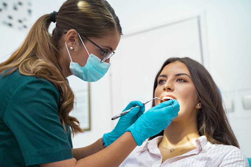 Orthodontic specialist examining a woman's mouth
