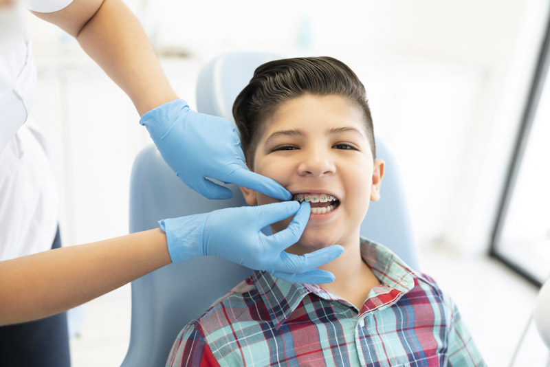 Young boy getting his braces checked by an orthodontic specialist