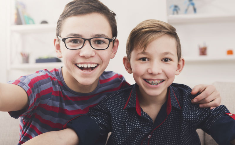 Boy wearing glasses next to a boy with braces